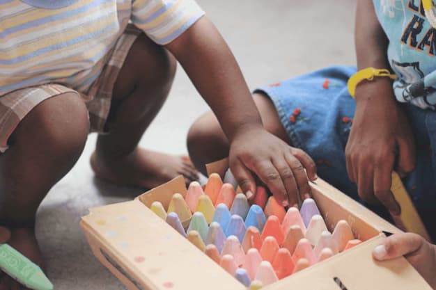 Crianças com uma caixa de giz exercitando seu aprendizado de matemática na Educação Infantil.