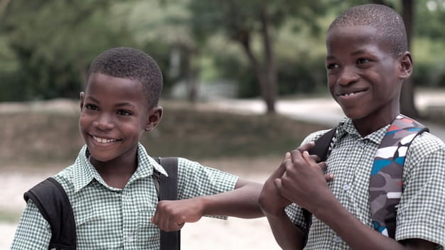 Duas crianças sorriem em um parque, ilustrando a motivação com gamificação na educação.