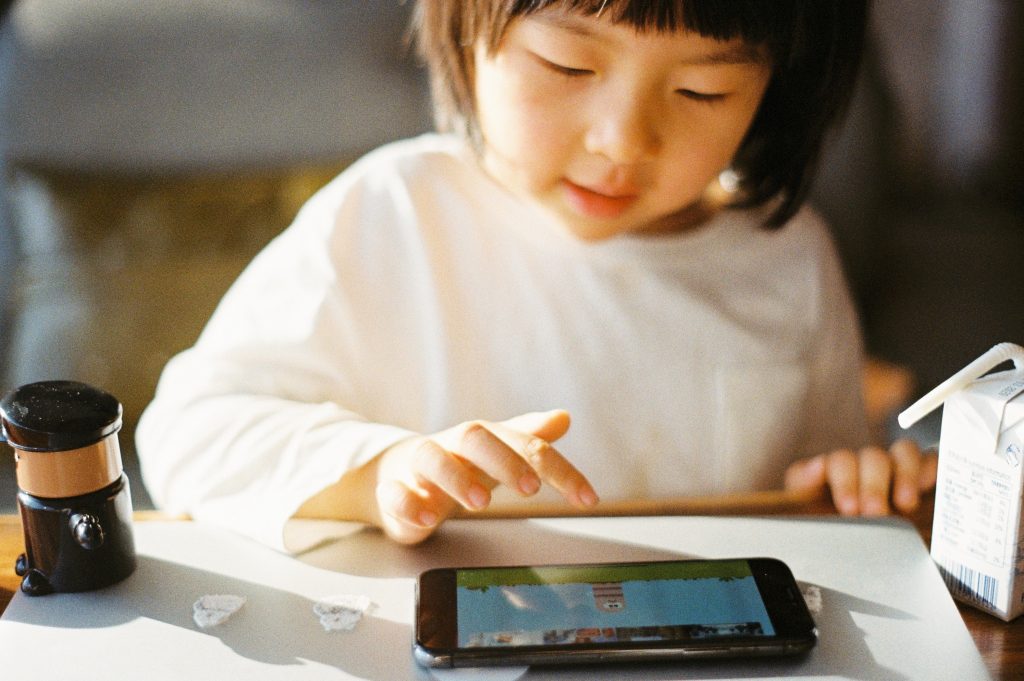Uma menina aprendendo com aplicativos para alfabetização com gamificação em um tablet. 