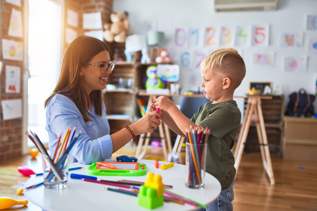 Professora utilizando os campos de experiência na Educação Infantil para ensinar seu aluno