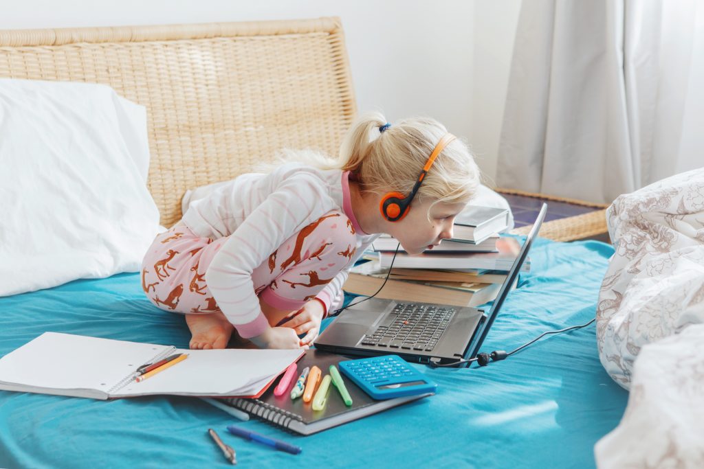 Menina estudando em casa utilizando a tecnologia educacional.