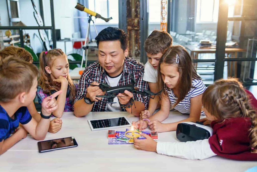 Professor ministrando aula a partir de seu plano de aula usando a tecnologia na educação infantil